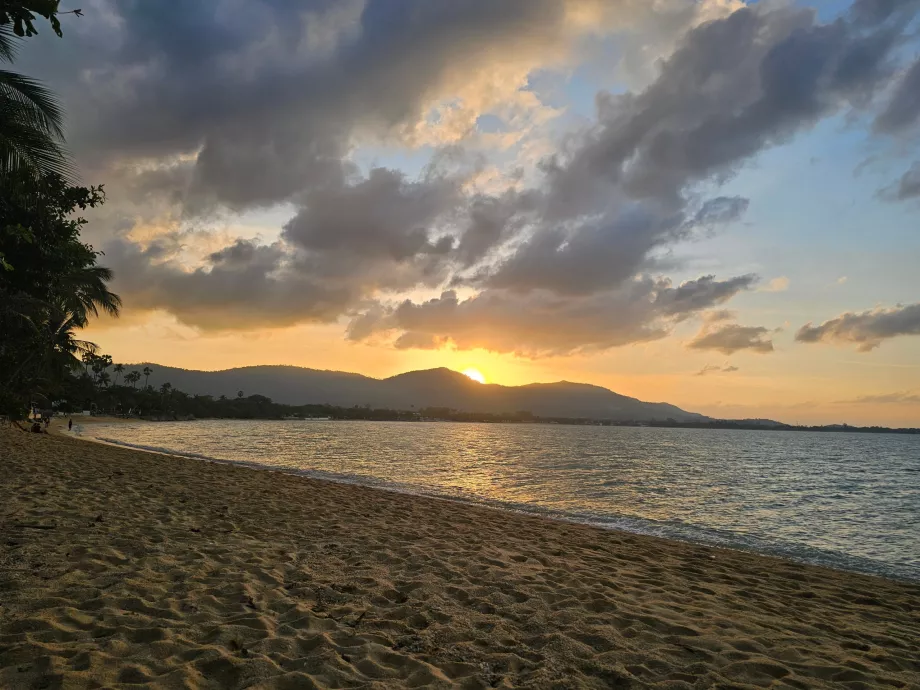 Matahari terbenam di atas pulau - pemandangan dari pantai hotel
