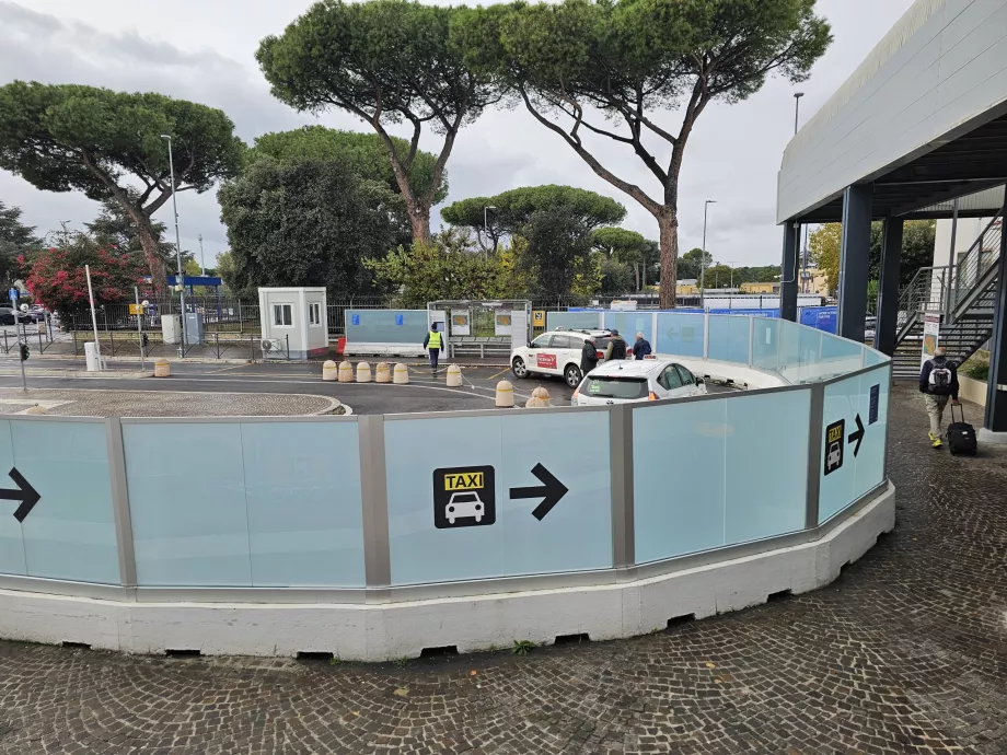 Taksi berdiri di depan aula kedatangan