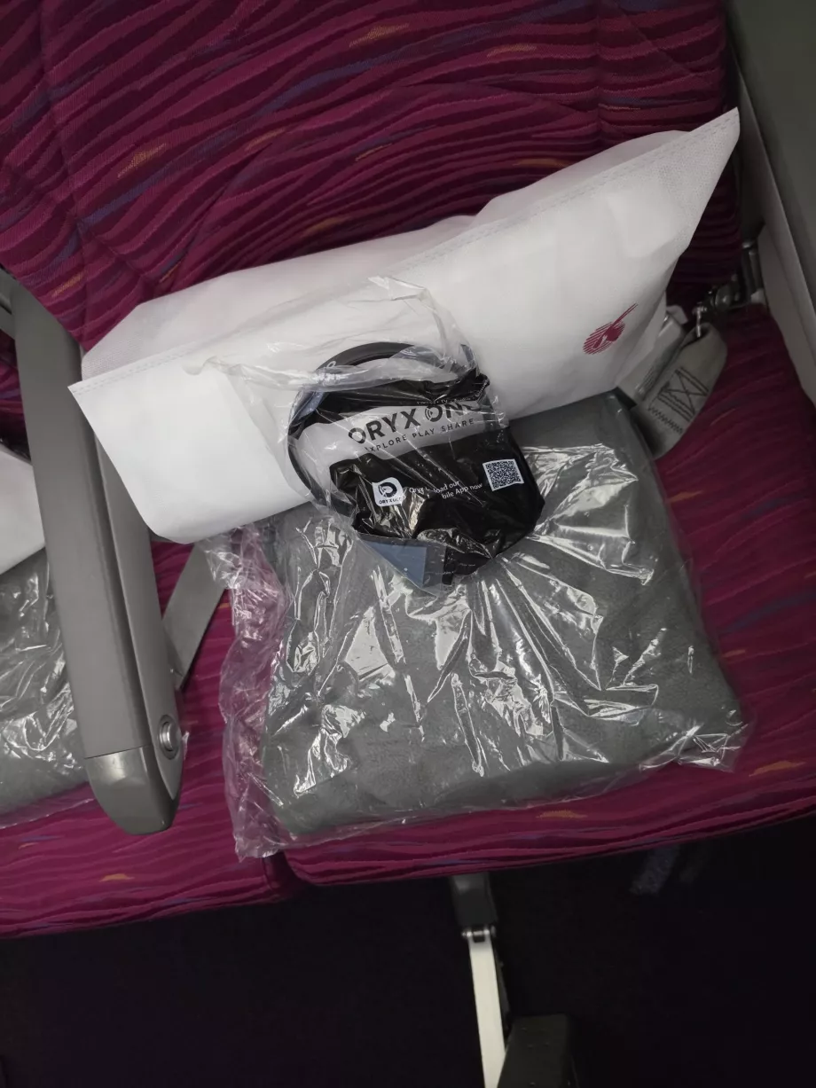 Sebuah bantal, selimut, dan headphone