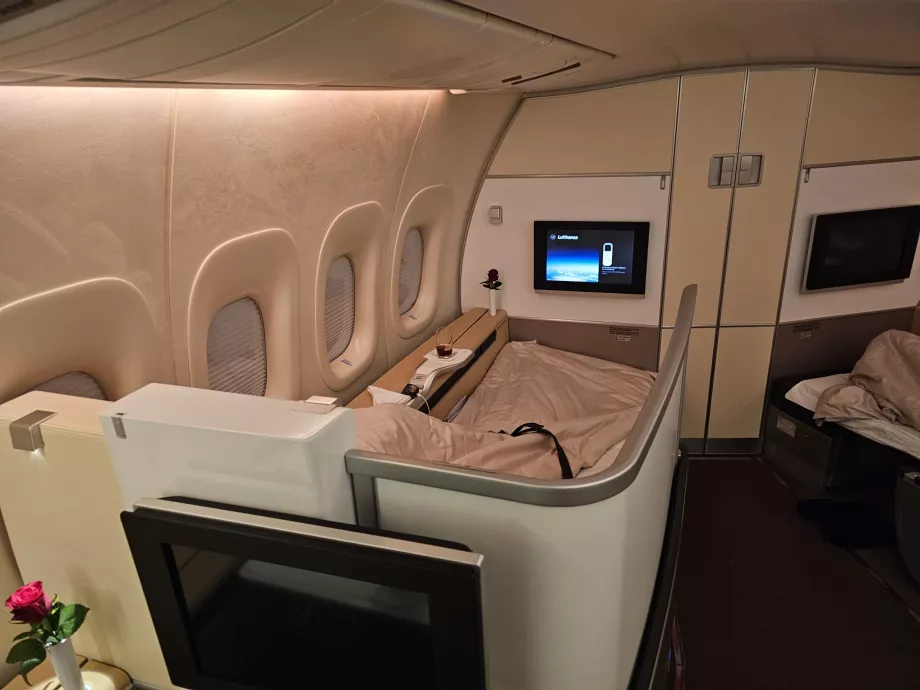 Layar yang dapat diperpanjang yang memisahkan tempat duduk dari koridor