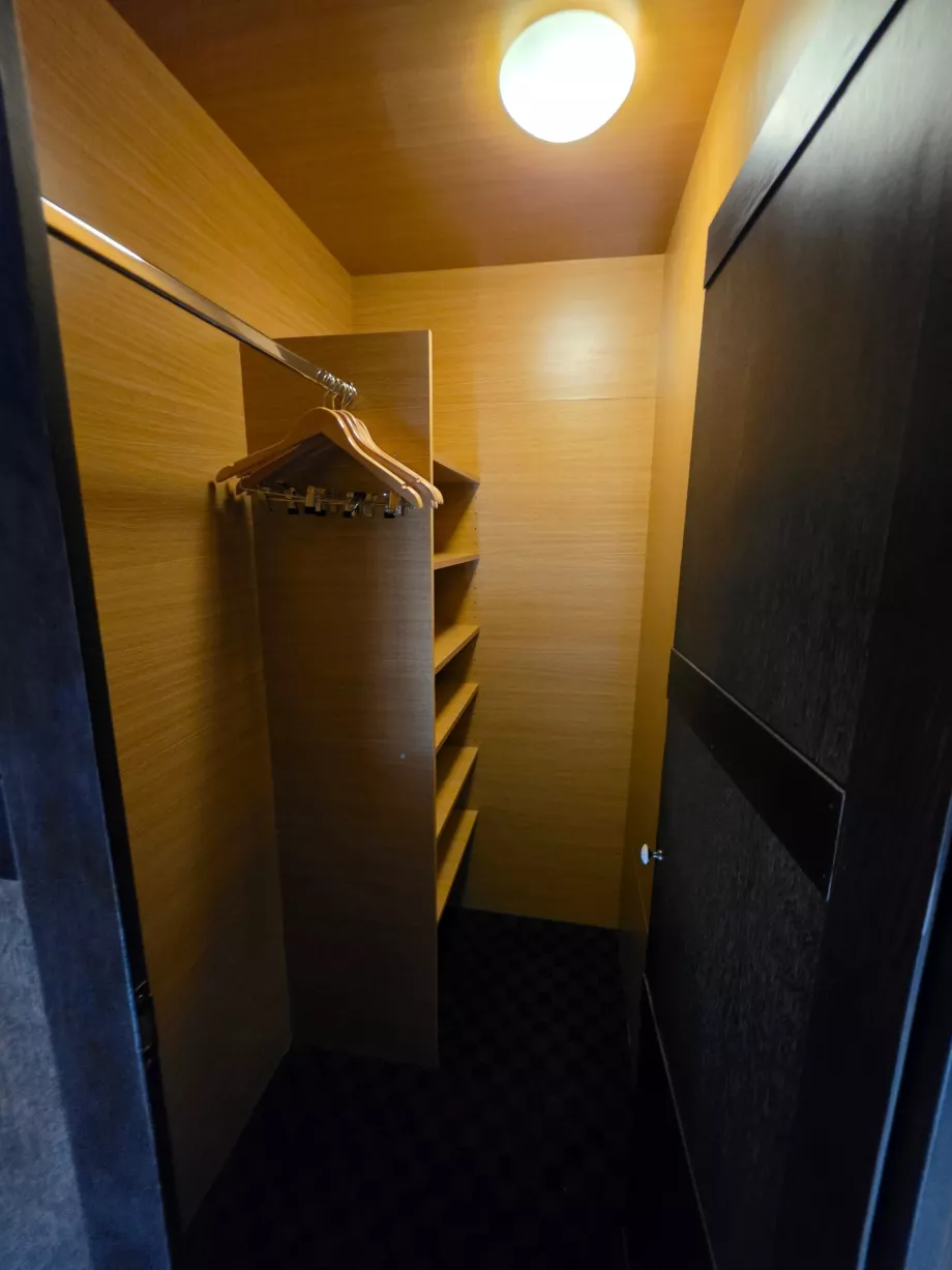 Lemari pakaian di belakang tempat tidur