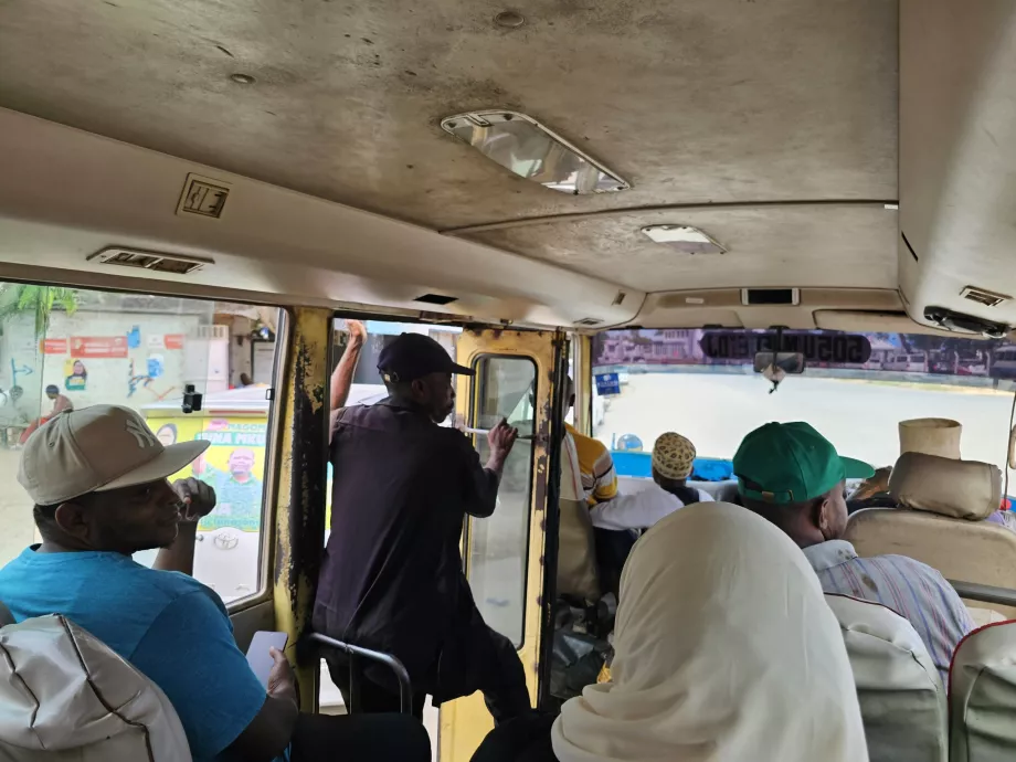 Kondektur di dalam bus memberikan